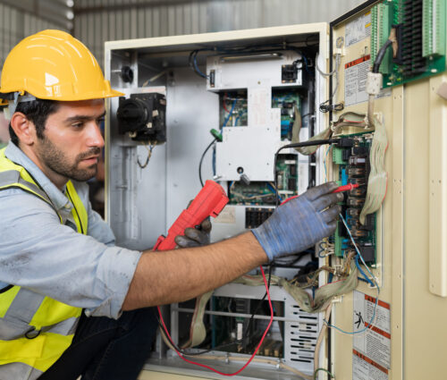 Male electrician worker checking, repair, maintenance operation electric system in factory. Male electrician using electrical meters working with operation electric system in workshop